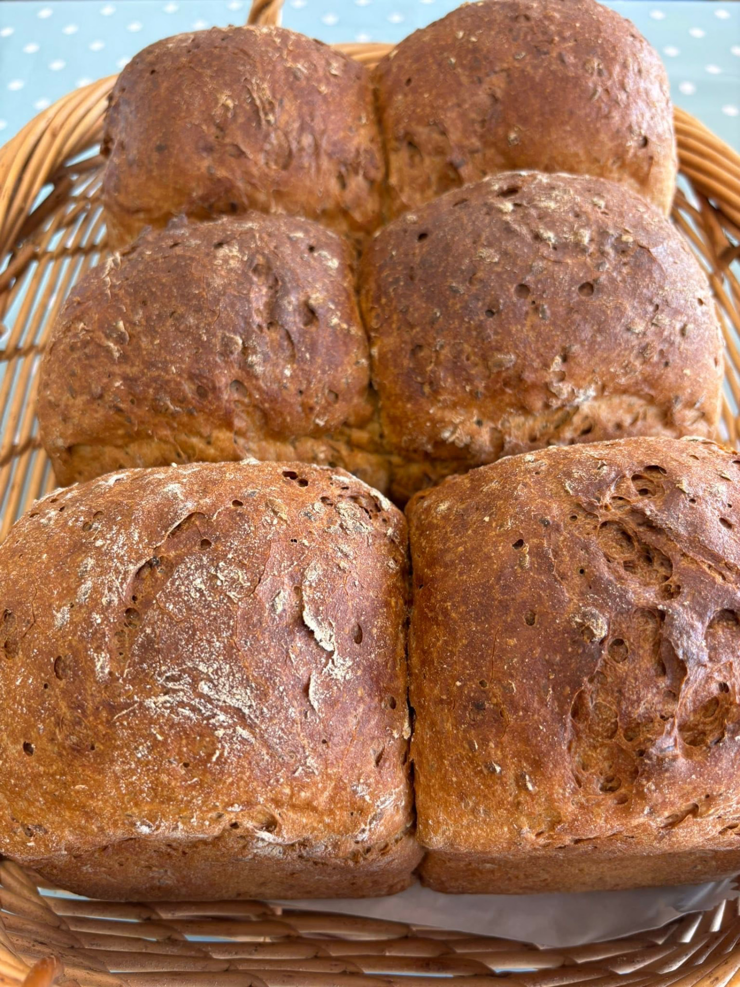 Basket of freshly baked gluten free seeded brown loaves
